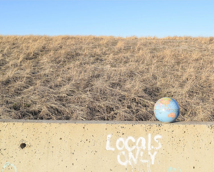 a photo of a globe sitting on a wall in front of a sand dune called Globe #6 by UNH student Alexandra Caggiano '16