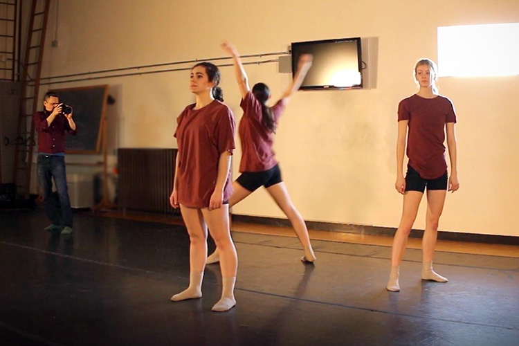 three women dancers rehearsing and a man photographing them