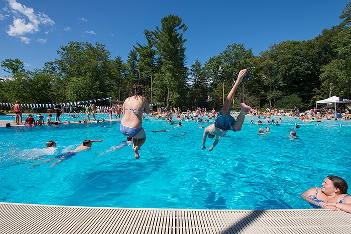 kids jumping into UNH's new outdoor pool at the opening