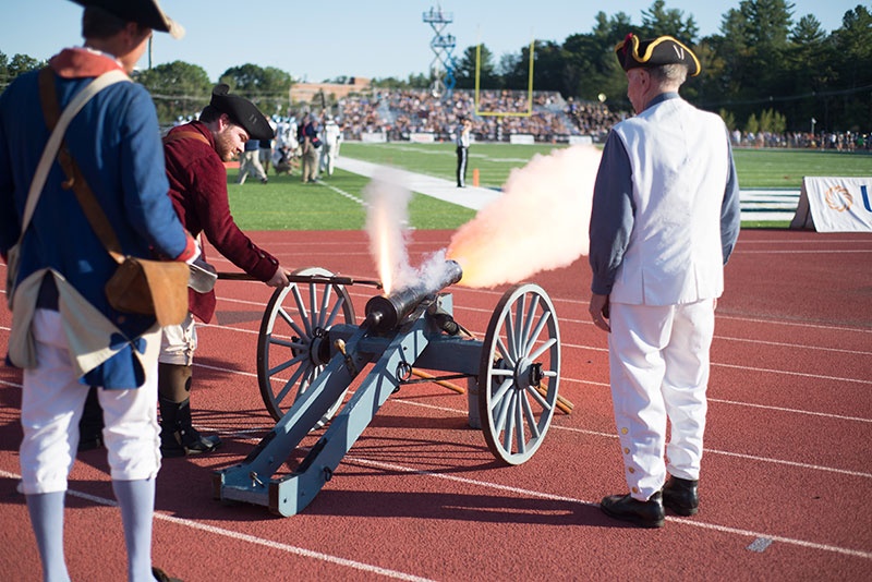 Dick Dewing and crew set off the cannon at a UNH football game