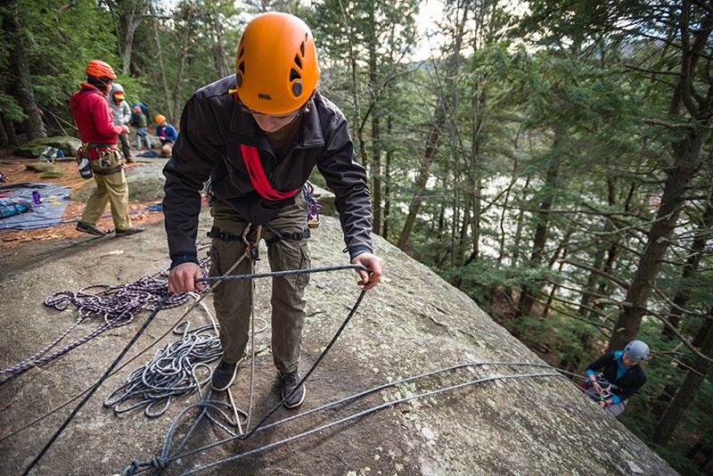 UNH student rappeling down a rock face