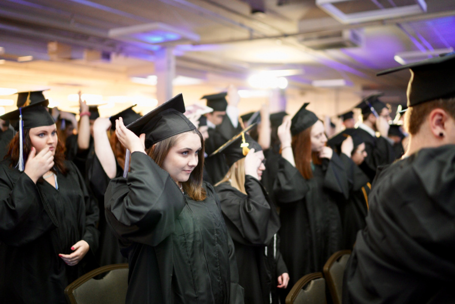 UNH Manchester students fix their tassels for graduation 