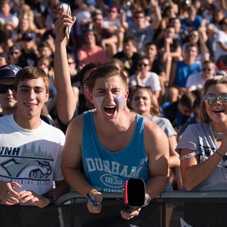 UNH students cheering at the homecoming football game
