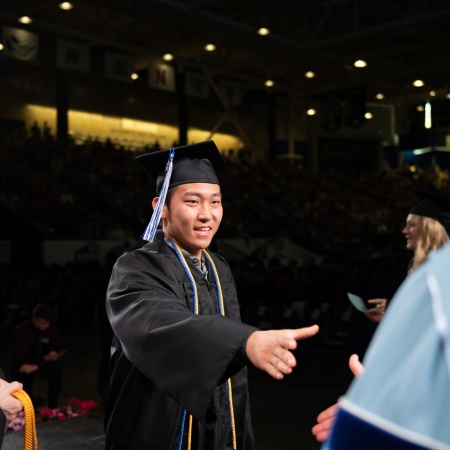 A UNH student receives their cord