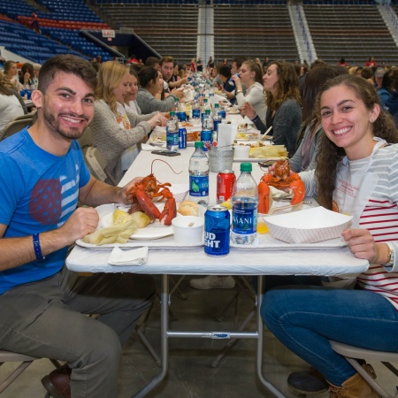 UNH seniors celebrating their impending graduation with classmates over lobster in the rough 