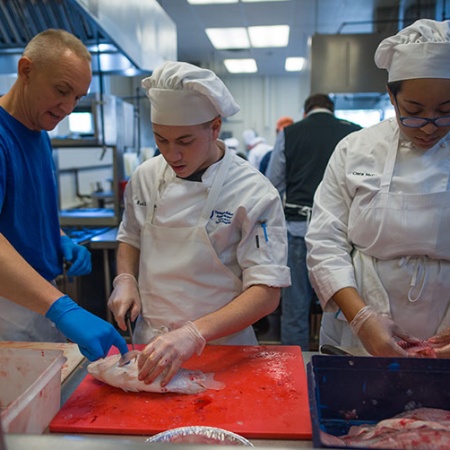 Brad LaMonica and Ciara McCarter from UNH’s Thompson School of Applied Science Culinary Arts & Nutrition program get a filet lesson from Rich Pettigrew, owner of Seaport Fish in Rye, N.H.