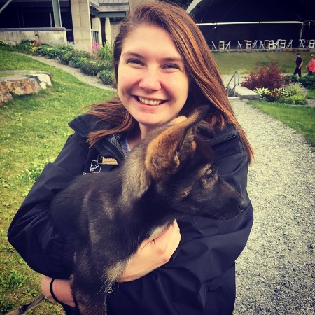Genevieve Wolfe holds a sled dog puppy