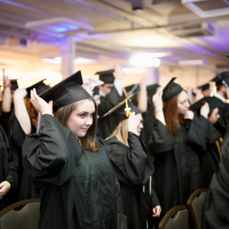 UNH Manchester students fix their tassels for graduation 