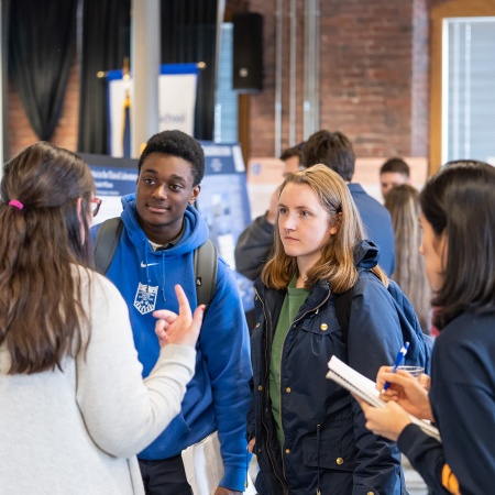 Students listening to a presenter describe her research during the UNH Manchester Undergraduate Research Conference 2018