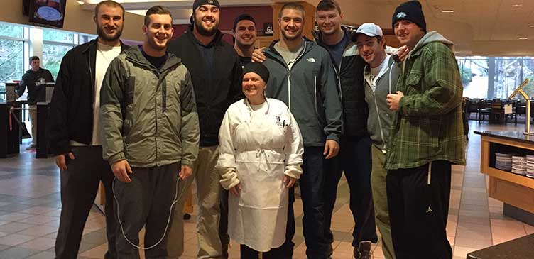 UNH football players with UNH chef on Thanksgiving