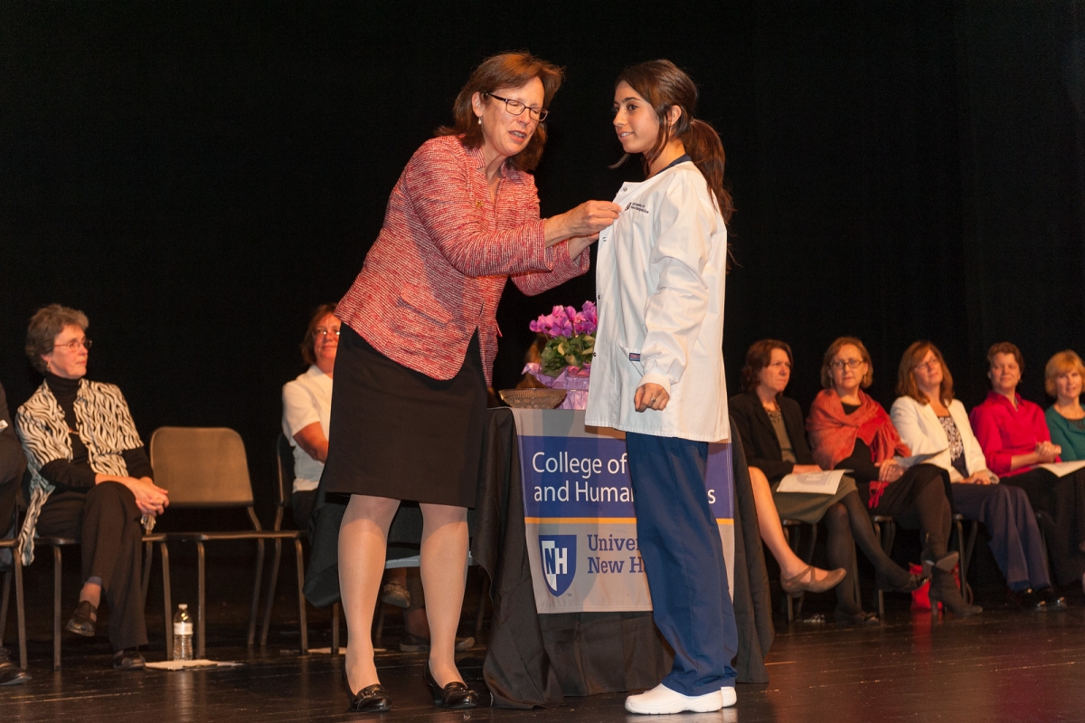UNH nursing student receiving compassionate care pin at white coat ceremony 