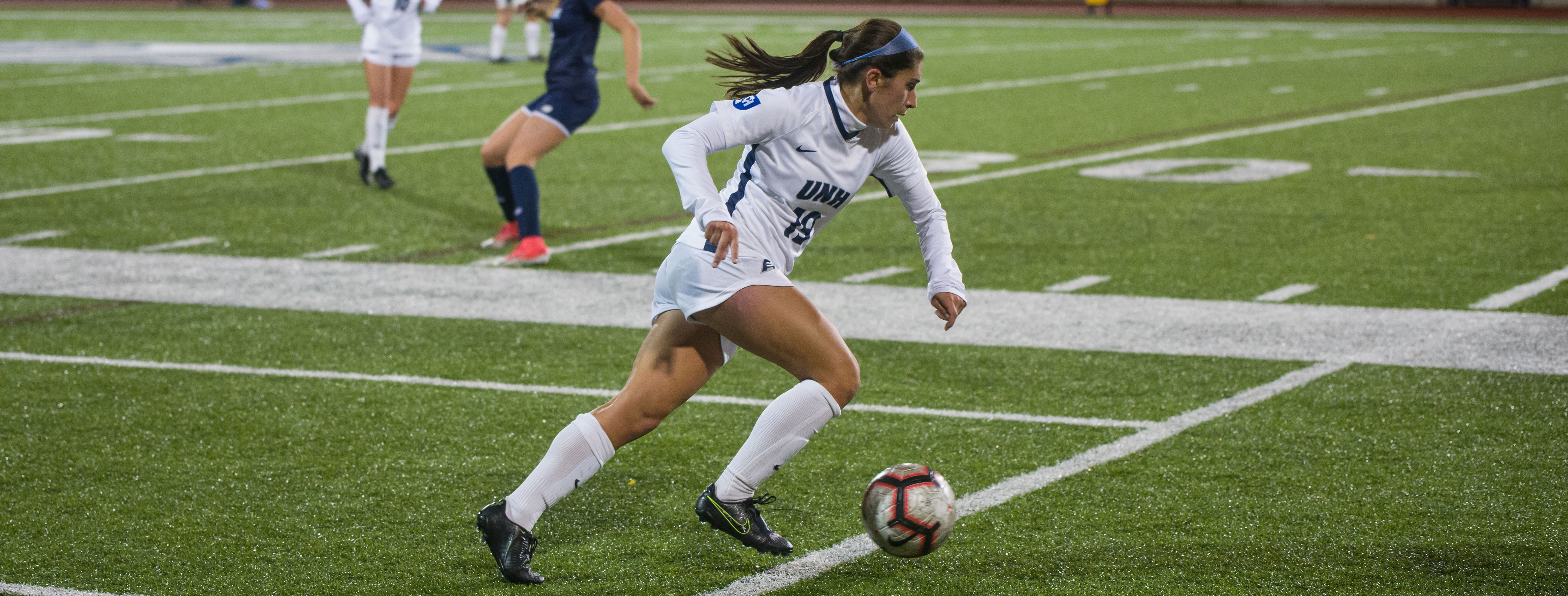 UNH women's soccer player moving the ball upfield