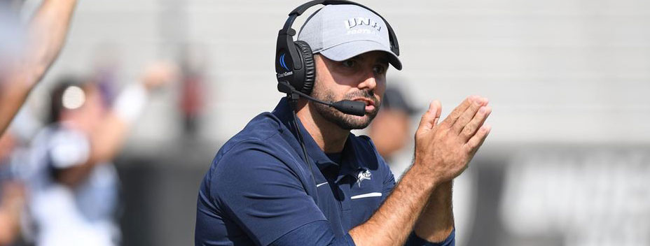 UNH Football Coach Rick Santos clapping on sideline