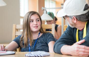 Child and teacher sitting at table chatting